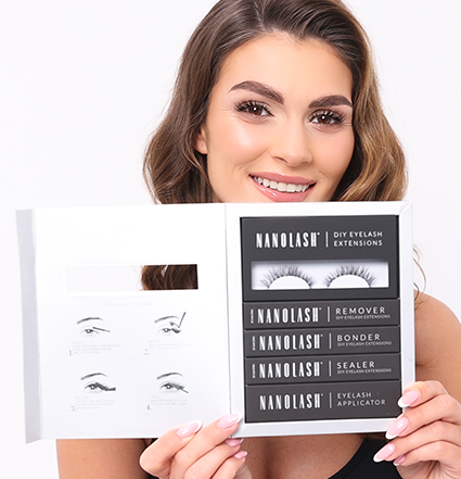 Model with a wide smile holding a lash extensions starter kit